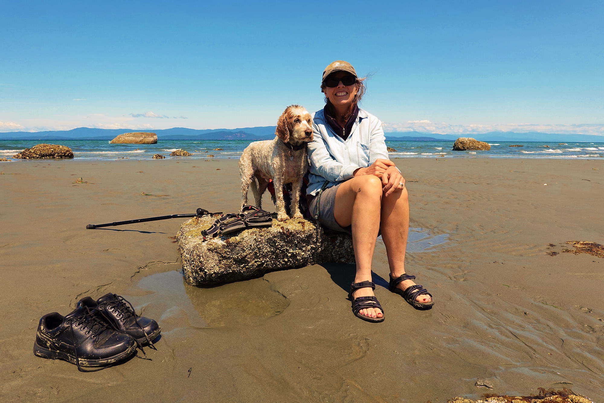Janine and Zeus sitting on a barnicle-encrusted rock